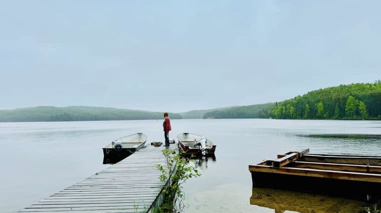 A person standing on the jetty, checking the weather at the Experimental Lakes Area before field sampling.