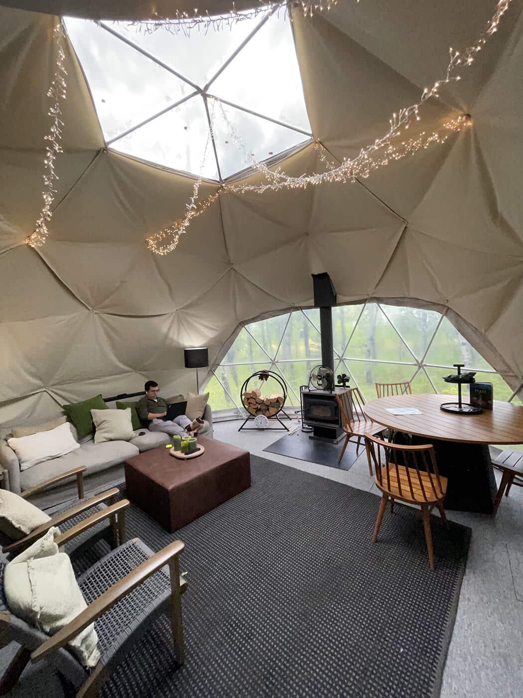 A researcher focuses on his writing in a forest dome during a research retreat.