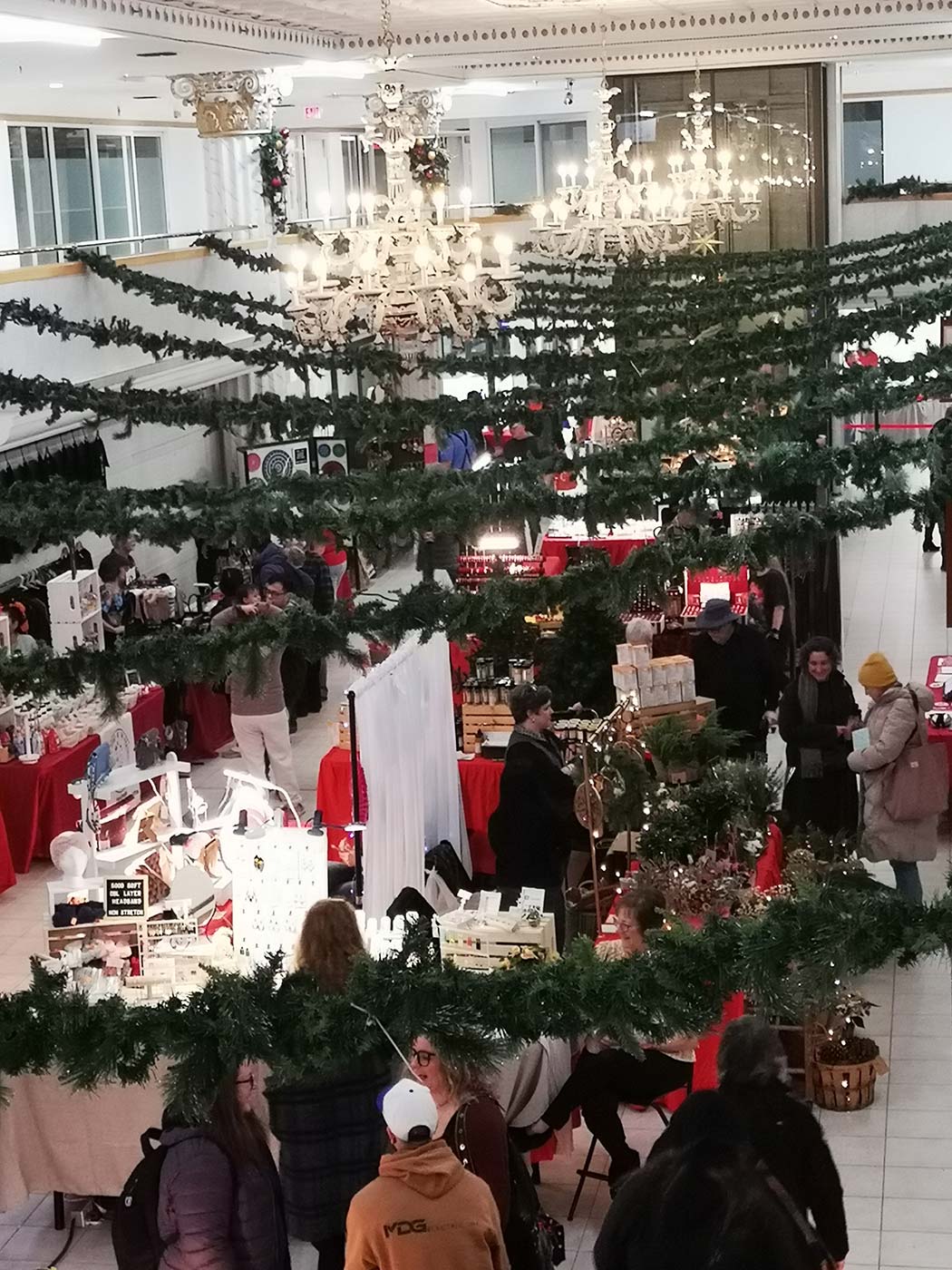 A lively scene from the German Christmas Market, with various tables selling handmade crafts, cheerful laughter, and a festive atmosphere.